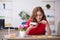 Young female designer having breakfast in the office