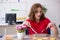 Young female designer having breakfast in the office