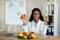 Young female dietitian holding apple and grapefruit at weight loss clinic, copy space