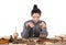 A young female doctor of Chinese medicine uses a medicine scale to weigh the medicine at the table full of various medicinal mater