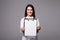 Young female doctor holding empty folder with files of desease illness. Specialist point by pen blank clipboard. Woman in medical