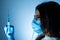 Young female doctor in a medical mask and gloves holds a syringe with a coronavirus vaccine and a vaccine chip inside. Conspiracy