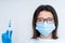 Young female doctor in a medical mask and gloves holds a syringe with a coronavirus vaccine and a vaccine chip inside. Conspiracy