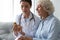 Young female doctor prescribe medicine bottle to old grandma patient