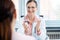 Young female doctor seeing woman patient