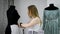 Young female dressmaker pinning and adjusting tissue on tailoring mannequin