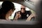 Young female driver in car and smiling policeman