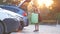 Young female driver loading luggage suitcase bag inside her car. Travelling and vacations concept