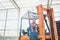 Young female driving forklift in greenhouse