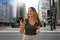 Young female entrepreneur watching her phone on Paulista Avenue in Sao Paulo finance district, Brazil