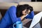 Young female executive dressed in blue asleep at home during telework time due to exhaustion from blue Monday.