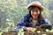 Young female farmer holds a tablet in a greenhouse filled with organic vegetables