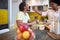 Young female feeding a male in the kitchen, smiling, having a good