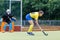 Young female field hockey player is going to score the goal