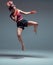 A young female fighter performs a jump kick.