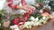 Young female florist with red ribbon for flowers