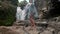 Young female in a flying clothes going up to the waterfall and begins her dance