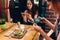 Young female food bloggers photographing their lunch with smartphones in restaurant