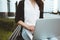 Young female freelancer making labor market research on modern laptop, sits on outdoors in urban street