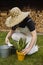 Young female gardener in bright dungarees replant seedlings in the garden. spring scenery. homemade plants transplanting
