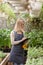 A young female gardener keeps a record of flowers in a greenhouse