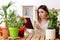 Young female gardener with plants indoors