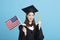 Young female graduation student showing the USA flag