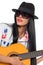 Young female guitarist wearing a hat