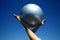 Young female gymnast with yoga ball held between legs