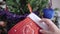 Young female hand hanging New Year mitten on Christmas tree. Unrecognizable Caucasian woman decorating house on holiday