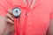 Young female hand holding stethoscope bright pink shirt in background