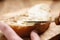 Young female hands spreading butter on bread