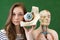 Young female high school student holding human eye model. Student in Biology class