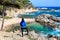 A young female hiker looking an amazing landscape in `Cala Estreta` beach, la Costa Brava, Catalonia, Spaon.
