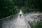 Young female hiker with pet dog on bridge