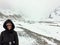 A young female hiker posing in front of the athabasca glacier along the columbia icefield parkway in Jasper National Park