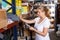 Young female holding shop list and choosing tools at shelves in build store