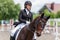 Young female horse rider on equestrian sport event