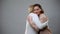 Young female hugging elderly mother on grey background, family connection, love