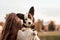 Young female hugging her Welsh Corgi dog in the autumn park