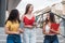 Young female latina college students, talking and walking happily, outside the university campus building