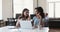 Young female mentor teach Black woman intern work on laptop