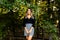 Young female model posing quietly in a park with a natural out of focus background dressed elegant