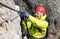 Young female mountain climber on a Via Ferrata in the Dolomites in Alta Badia clicking carabiners in the cable