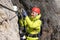 Young female mountain climber on a Via Ferrata in the Dolomites in Alta Badia clicking carabiners in the cable