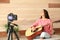 Young female musician recording video at home