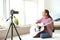 Young female musician recording video indoors