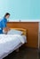 Young female nurse holds a white pillow over the hospital bed