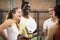 Young female paddle tennis player talking to friends on indoor court