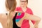 Young female patient wearing kinesio tape on her shoulder exercising with a professional physical therapist. Kinesiology.